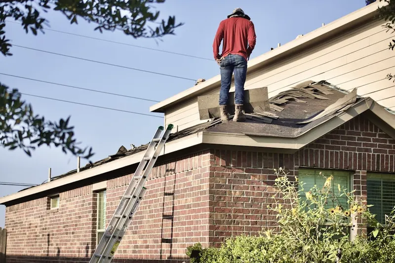 Professional roofer working on a residential roof in De La Salle